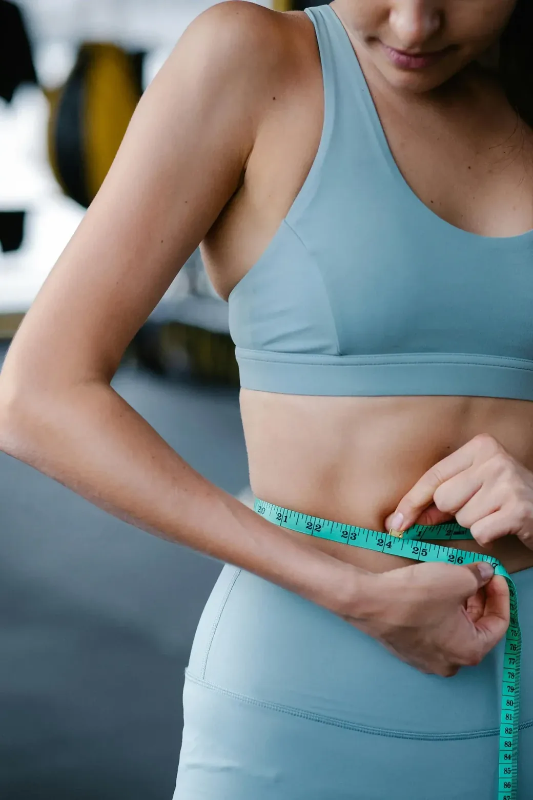 Stock photograph of someone measuring their waist with a tape measure